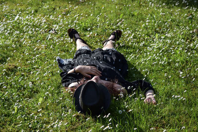 High angle view of teenage girl relaxing on grassy field