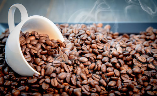 Close-up of cup in roasted coffee beans