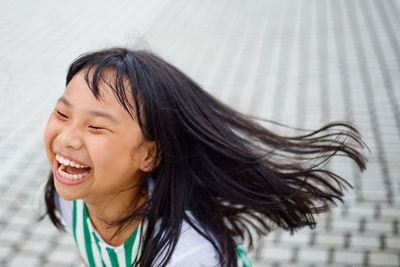 Close-up of girl laughing on footpath