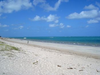 Scenic view of beach against cloudy sky