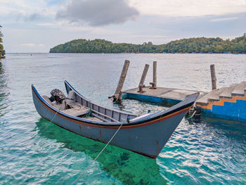 Boat moored in sea against sky