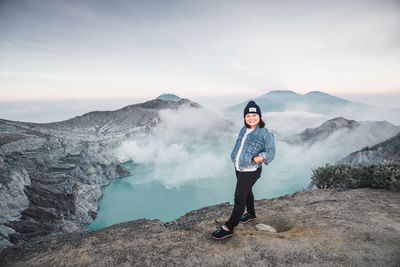 Full length portrait of woman standing on mountain