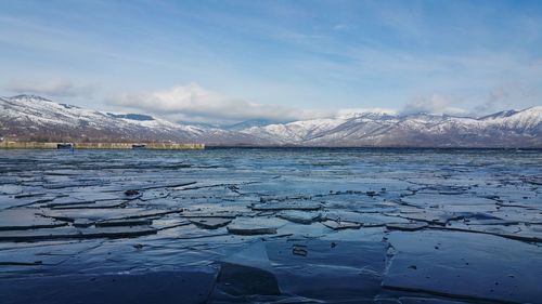 Scenic view of lake and snowcapped mountains against sky