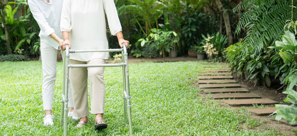 Rear view of woman with umbrella walking on grass