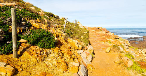 Rock formation on beach against sky