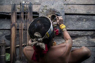 Directly above shot of man applying herbs on arrow
