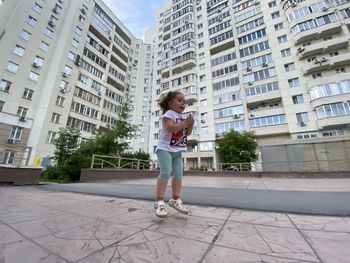 Full length of woman on street against buildings in city