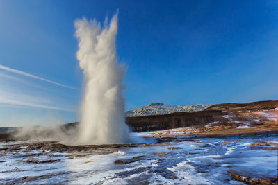 The great geysir erupting on a daily landscape, golden circle, iceland