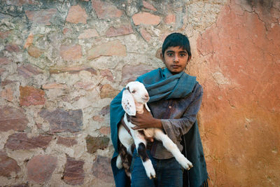 Portrait of teenage girl against wall