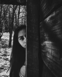 Portrait of woman standing by tree in forest