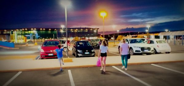 Cars on road against illuminated city at night