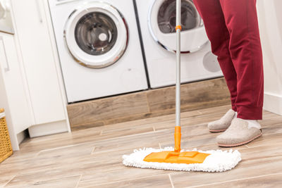 Low section of person cleaning floor