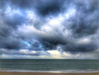 Scenic view of sea against storm clouds