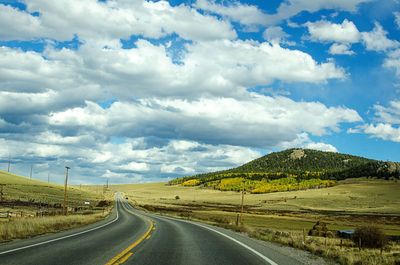 Country road against cloudy sky