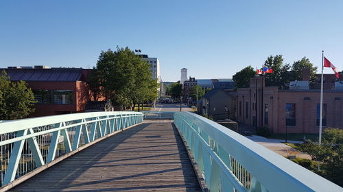 Footbridge against buildings in city