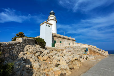 Lighthouse by sea against sky