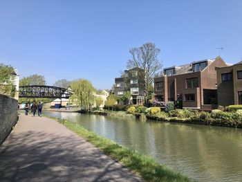 River by buildings against clear sky