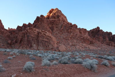 Low angle view of rock formations against clear blue sky