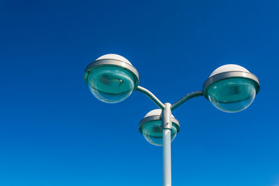 Low angle view of street light against clear blue sky