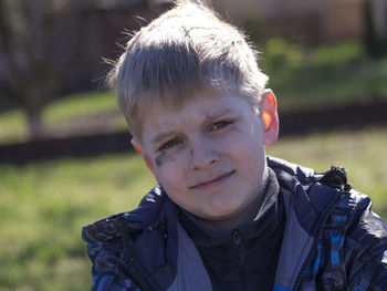 Close-up portrait of boy with soot smear on face