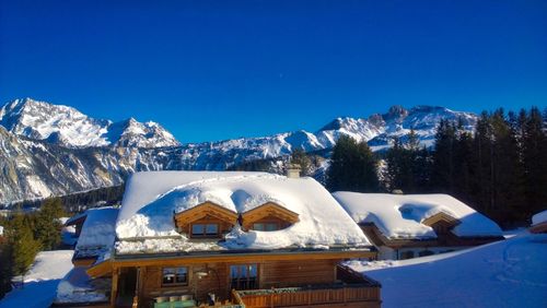 Snow covered mountains against blue sky