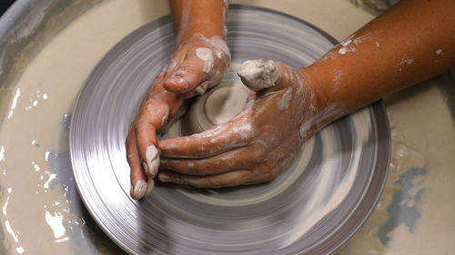 Cropped hand making pottery