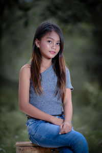 Portrait of young woman sitting on field