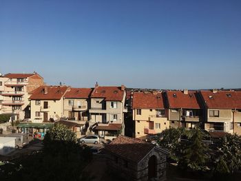 Houses in town against clear blue sky