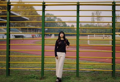 Portrait of woman standing against sports field