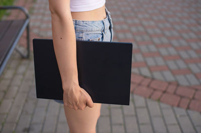 Low section of woman using digital tablet