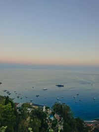 High angle view of townscape by sea against clear sky during sunset
