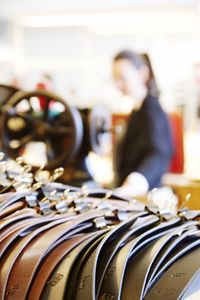 Close-up of leather belts by woman at store