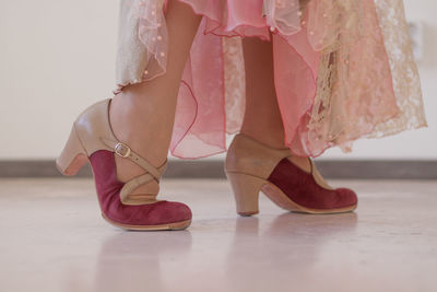 Pink and beige shoes for flamenco dance on women's legs. close-up.