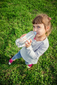 Portrait of young woman drinking water bottle