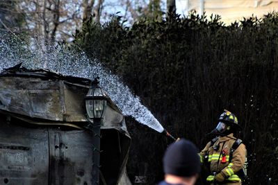 Firefighter spraying water on built structure