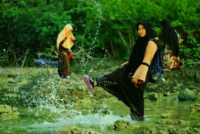 Full length of woman sitting in water