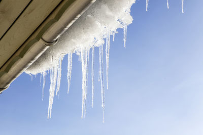 Icicles on roof against clear sky
