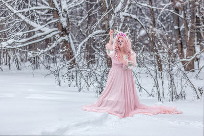 Portrait of woman standing on snow covered field