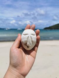 Midsection of person holding crystal ball on beach