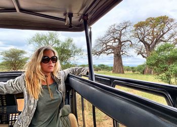 Woman with blond hair sitting in safari vehicle at national park