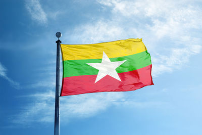 Low angle view of flag against blue sky