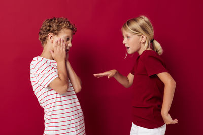 Sibling dancing against red background