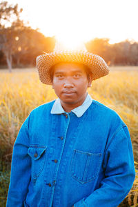 Portrait of man wearing hat standing on field