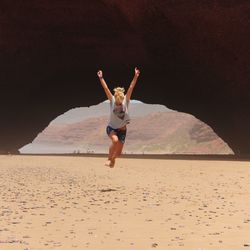 Full length of woman jumping at beach