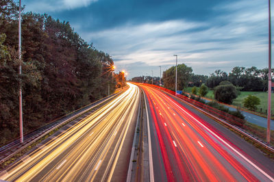 Light trails on highway against sky in city