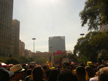 People on street in city against sky