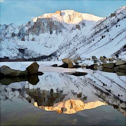 Scenic view of lake by snowcapped mountains against sky