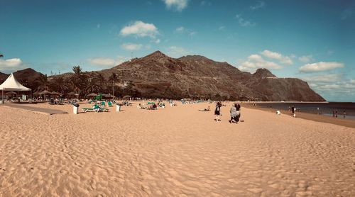 Group of people on beach against sky