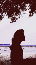 Rear view of silhouette woman at beach against sky