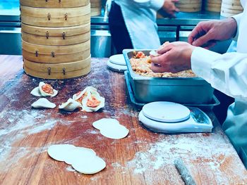 Midsection of person preparing food on table